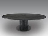 une table noire avec un plateau circulaire et un piètement en métal