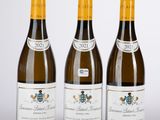 trois bouteilles de vin posées sur une table l'une à côté de l'autre