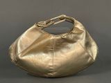 gold leather handbag on grey background with silver background