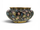 une image représentant un vase noir et doré orné de fleurs
