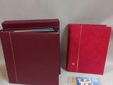 two red binders and a book are sitting on a table