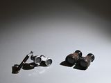 two pairs of binoculars sitting on a white surface
