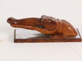 wooden sculpture of an elephant on a stand on a white surface
