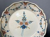 two plates with flowers painted on them on a table