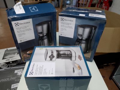 deux cafetières encore dans leur emballage, posées l'une à côté de l'autre sur une table