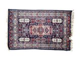 a blue and red rug with fringes on a white background
