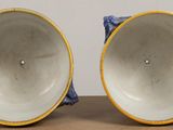 two blue and yellow vases sitting on top of a wooden table