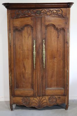 Armoire en bois naturel mouluré et sculpté. XIXe siècle.