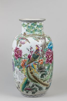 un vase blanc orné d'un oiseau et de fleurs