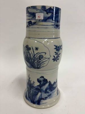 un gros plan d'un vase posé sur une surface blanche, orné de motifs bleus et blancs