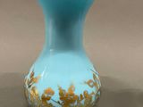 a blue vase with a gold design on it