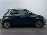 the small blue car is parked in the room on the concrete floor