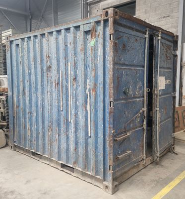 un conteneur d'expédition bleu dans un entrepôt, dont la porte est ouverte