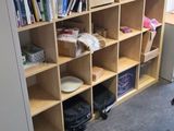a desk with a chair and bookshelf in the corner
