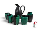 five cups and a pitcher sitting next to each other on a table