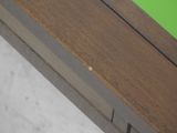 a close up of a wooden bench with a green seat