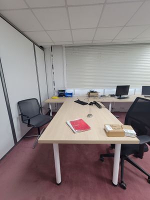 une photo d'un bureau vide avec un bureau et des chaises