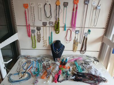 a table that has a bunch of necklaces on it