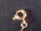 a gold charm with a heart on it on a black surface