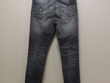 a pair of jeans hanging on a hanger against a wall