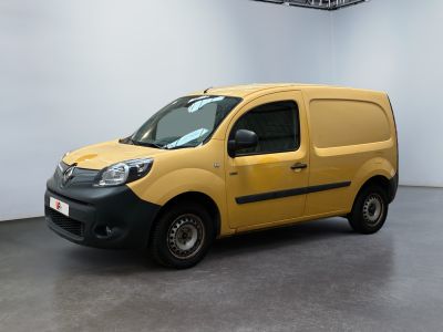La camionnette jaune est garée dans une grande pièce aux murs blancs.