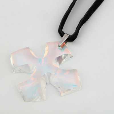 a glass cross pendant on a black cord