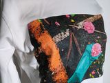 the back of a white shirt with a picture of a bird and flowers on it