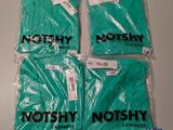 four bags of notshy t - shirts are sitting on a table