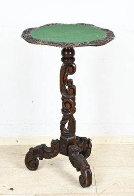 une photo d'une petite table au plateau vert posée sur un parquet