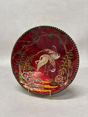 a red plate with a bird on it on a white background
