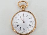 a gold pocket watch with roman numerals on the face
