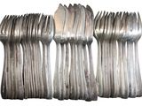 a lot of forks and spoons sitting on a table