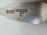 a silver spoon with a metal handle on a table