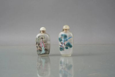 two small glass bottles sitting on top of a table