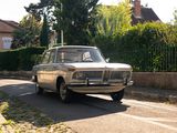 une voiture qui roule dans la rue devant une clôture