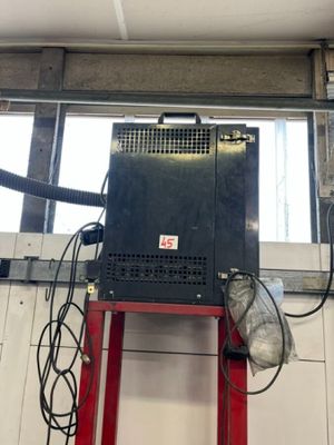 une photo d'un garage avec une échelle rouge et une machine noire