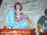 deux figurines représentant un homme et une femme assis sur un coussin