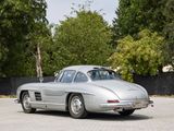 a silver car parked in a parking lot with trees in the background