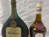 two bottles of liquor sitting next to each other on a white surface