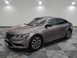 Une voiture grise est garée dans une pièce au sol carrelé en damier.