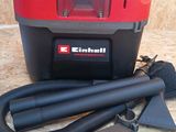 an image of a red and black vacuum with a hose and other items