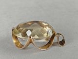 a close up of a yellow topaz quartz pendant on a white surface