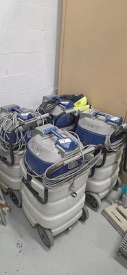 several vacuums are lined up in a room next to a wall