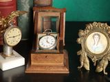 three clocks and a picture frame on a table