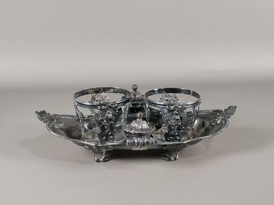 un plateau en argent posé sur une table, sur lequel se trouvent trois tasses