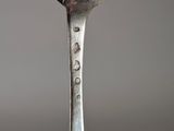 a silver spoon with a silver handle on a table