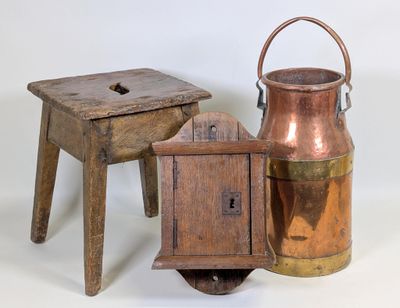 deux tabourets en bois et un pichet en cuivre sur fond blanc