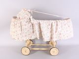 a wooden baby carriage with a floral cover on top of it
