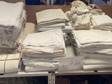 plusieurs piles de serviettes blanches pliées sur une étagère dans un magasin