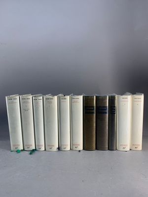 plusieurs livres sont alignés sur une surface grise